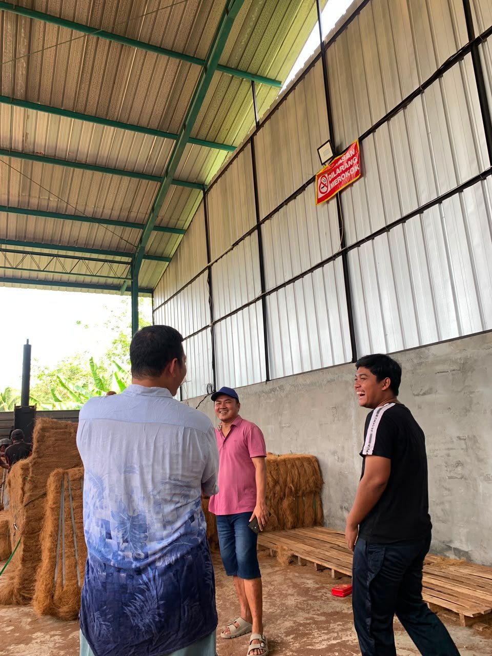 Tim berdiskusi di gudang produksi sebelum pengiriman